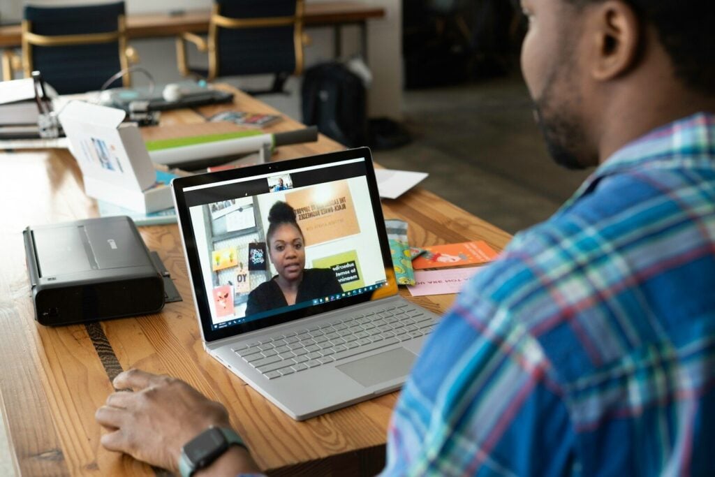 man in blue and white plaid shirt using macbook pro